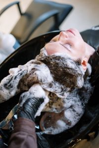 Woman having her hair washed at a salon with shampoo