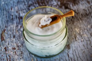 Refined shea butter and a tiny wooden spatula in a mini jar