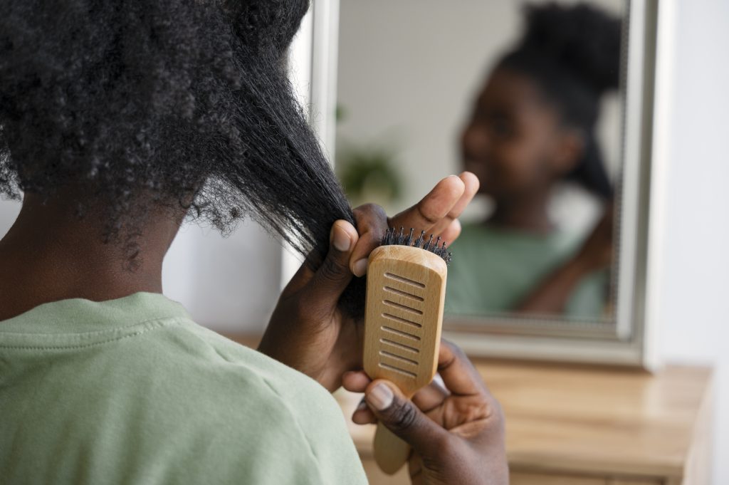 Back view of a lady combing her hair after a protein treatment